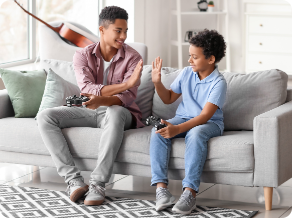 teenage boys playing video games on couch